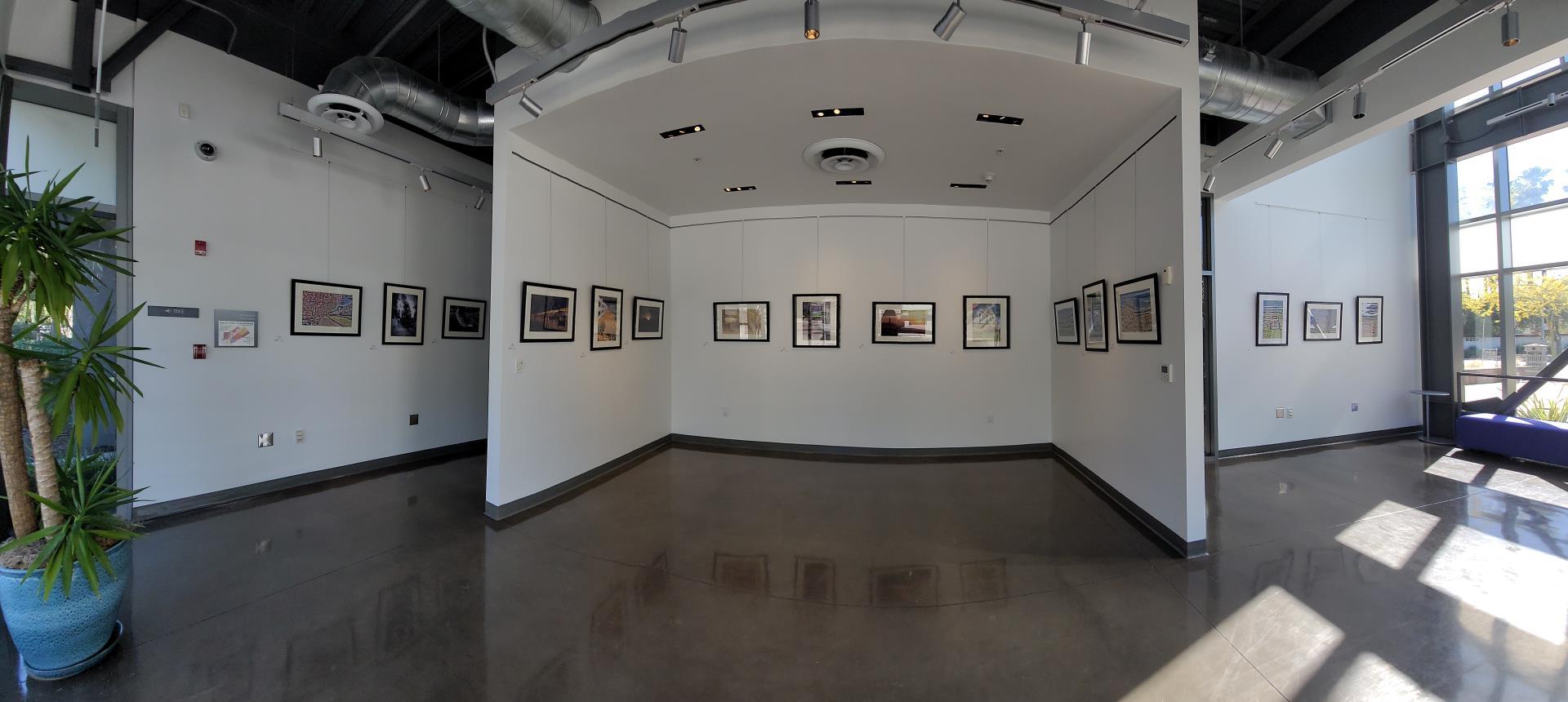 A panorama of an art gallery, framed photos hanging on all the walls.